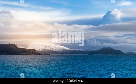 Paysage d'hiver et de mer panoramique à couper le souffle avec des montagnes enneigées et de beaux nuages en arrière-plan. Mer norvégienne, Norvège, Scandinavie. Banque D'Images