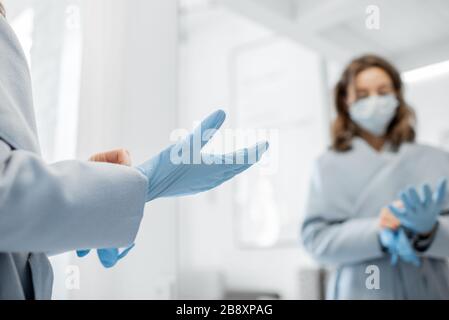 Femme dans un masque médical portant des gants en allant à l'extérieur, protégeant du virus pendant une épidémie. Concept de pandémie de coronavirus et protection contre les infections virales Banque D'Images