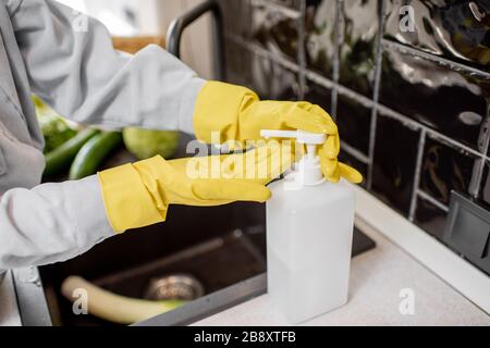 Femme appliquant du détergent sur les mains pendant le lavage des légumes à la maison Banque D'Images