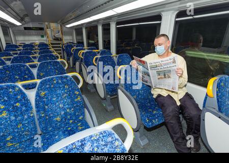 23 mars 2020 : un homme solitaire dans un train vide lit les nouvelles du coronavirus du journal Sydney Morning Herald à Sydney, en Australie, alors que la population abandonne les lieux publics en prévision d'un confinement dans toute la ville. À partir de midi aujourd'hui, de nombreux commerces et lieux de rassemblement classés par le gouvernement comme non essentiels - tels que les pubs, les restaurants, les plages et même les lieux de culte - ont été considérés comme interdits jusqu'à nouvel ordre. Crédit : Robert Wallace / Wallace Media Network / Alamy Live News. Banque D'Images