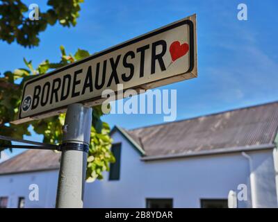 Photo haute résolution d'un panneau de rue pour la rue Bordeaux avec un autocollant rouge coeur dans la ville viticole et touristique de Franschhoek. Banque D'Images