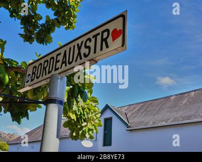 Photo haute résolution d'un panneau de rue pour la rue Bordeaux avec un autocollant rouge coeur dans la ville viticole et touristique de Franschhoek. Banque D'Images