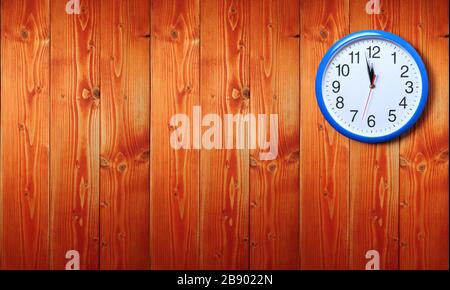 Horloge murale bleue avec minuit nouvel an sur fond en bois Banque D'Images