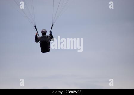 Concept de succès. Un homme parapente dans un ciel clair Banque D'Images