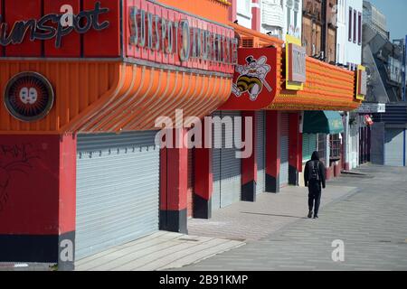 Un homme passe devant des arcades de divertissement fermées sur le Golden Mile sur le front de mer de Southend dans l'Essex, comme le Premier ministre Boris Johnson l'a dit, le gouvernement est prêt à imposer des restrictions plus sévères pour freiner la propagation du coronavirus si les gens ne suivent pas les directives sur la distanciation sociale. Banque D'Images