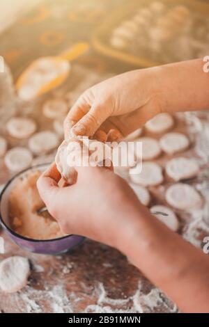 Femme dans la cuisine prépare des boulettes pour le petit déjeuner, plat folklorique ukrainien.2020 Banque D'Images