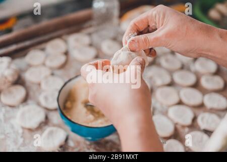 Femme dans la cuisine prépare des boulettes pour le petit déjeuner, plat folklorique ukrainien.2020 Banque D'Images