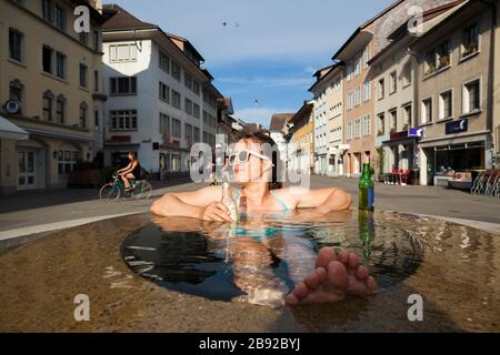 Mylène Jacquemart se refroidit dans une fontaine de Steinberggasse, Winterthur, Suisse. Les trois fontaines elliptiques de la rue, conçues par le Am Banque D'Images