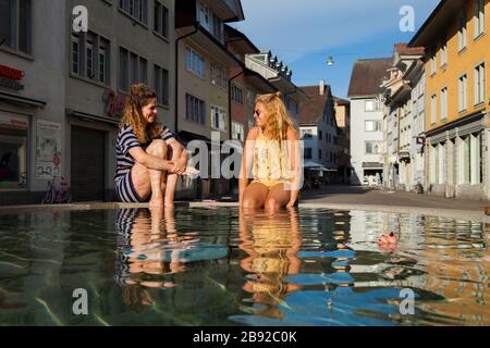 Les femmes s'imprégnent de leurs pieds dans une fontaine sur Steinberggasse, Winterthur, Suisse. Les trois fontaines elliptiques de la rue, conçues par les Américains Banque D'Images