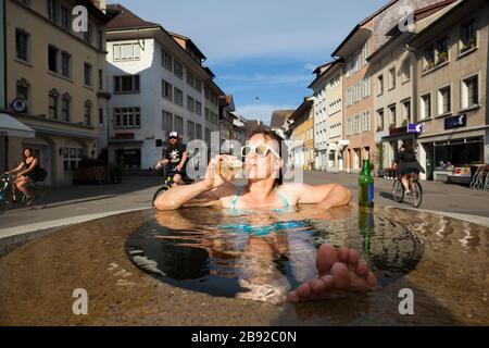 Mylène Jacquemart se refroidit dans une fontaine de Steinberggasse, Winterthur, Suisse. Les trois fontaines elliptiques de la rue, conçues par le Am Banque D'Images