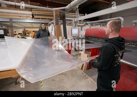 Urmitz, Allemagne. 23 mars 2020. Les employés de l'entreprise action Light, qui gère normalement la technologie des événements et la construction des stands d'exposition, coupent des feuilles de Plexiglas pour les murs de protection des caisses de supermarché et des opérations chirurgicales des médecins. Les caissiers dans les supermarchés en particulier peuvent se infecter et ensuite leurs clients avec la maladie pulmonaire corona. (Vers dpa 'Company passe à la production de cloisons pour les caissiers') crédit: Thomas Frey/dpa/Alay Live News Banque D'Images