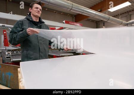 Urmitz, Allemagne. 23 mars 2020. Les employés de l'entreprise action Light, qui gère normalement la technologie des événements et la construction des stands d'exposition, coupent des feuilles de Plexiglas pour les murs de protection des caisses de supermarché et des opérations chirurgicales des médecins. Les caissiers dans les supermarchés en particulier peuvent se infecter et ensuite leurs clients avec la maladie pulmonaire corona. (Vers dpa 'Company passe à la production de cloisons pour les caissiers') crédit: Thomas Frey/dpa/Alay Live News Banque D'Images