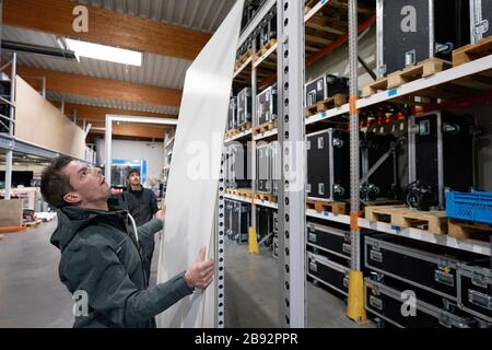 Urmitz, Allemagne. 23 mars 2020. Les employés de l'entreprise action Light, qui exploite normalement la technologie des événements et la construction de stands d'exposition, installent des murs de protection devant l'entrepôt avec des équipements technologiques d'événements pour les contrôles de supermarché et les pratiques médicales. Les caissiers dans les supermarchés en particulier peuvent se infecter et ensuite leurs clients avec la maladie pulmonaire corona. (Vers dpa 'Company passe à la production de cloisons pour les caissiers') crédit: Thomas Frey/dpa/Alay Live News Banque D'Images