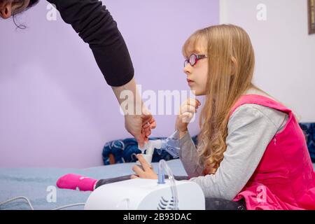 La femme prépare un traitement par inhalation pour les enfants souffrant de problèmes asthmatiques, de thérapie à domicile. Banque D'Images