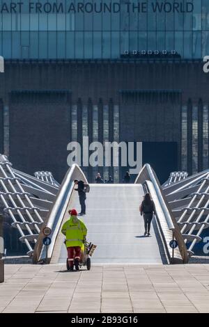 Londres, Royaume-Uni. 23 mars 2020. Services de nettoyage essentiels et touristes sur le pont du Millénaire devant le Tate Modern sous le message, de partout dans le monde - Anti Coronavirus (Covid 19) épidémie à Londres. Crédit: Guy Bell/Alay Live News Banque D'Images