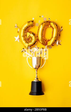 Le ballon de célébration du numéro 60 de l'anniversaire de l'or explose à partir d'un trophée gagnant Banque D'Images