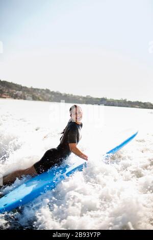 Jeune femme à l'approche du surf sur une planche de surf. Banque D'Images