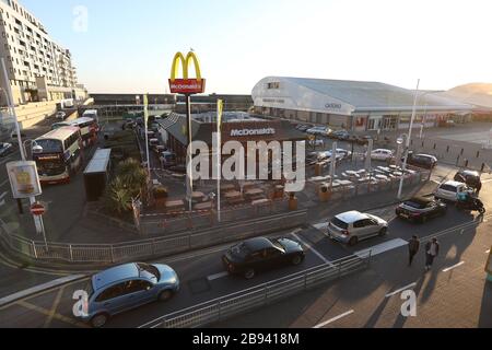 Brighton, Royaume-Uni. 23 mars 2020. Les clients du McDonalds qui font la queue dans leurs voitures peu avant que le restaurant Fast-food ne ferme ses portes en raison de l'épidémie de Coronavirus. Crédit: James Boardman/Alay Live News Banque D'Images