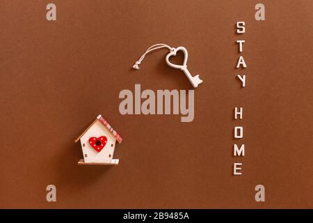 Les mots restent à la maison à partir de lettres en bois, des figures en bois de la maison et de la clé, concept d'auto-quarantaine à la maison comme mesure préventive contre la couronne Banque D'Images