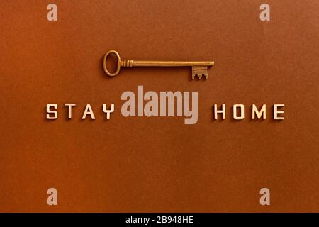 Les mots restent à la maison à partir de lettres en bois et clé, concept d'auto-quarantaine à la maison comme mesure préventive contre l'épidémie de Covid 19 de virus corona. Banque D'Images