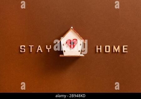 Les mots restent à la maison à partir de lettres en bois et de chiffres en bois de la maison, concept d'auto-quarantaine à la maison comme mesure préventive contre le virus de la couronne Banque D'Images