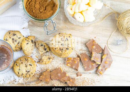 Chocolat chaud épicé avec bâton de cannelle et cookies aux pépites de chocolat sur fond en bois Banque D'Images