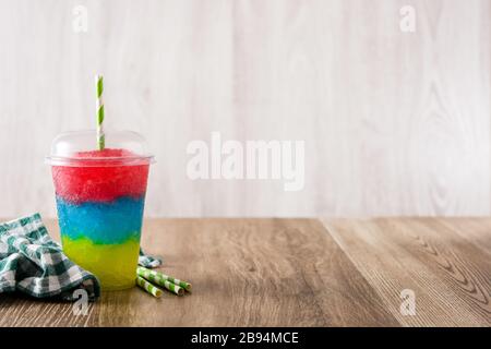 Slushie colorée de différentes saveurs avec paille dans une tasse en plastique. Espace de copie Banque D'Images