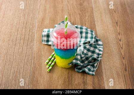 Slushie colorée de différentes saveurs avec paille dans une tasse en plastique Banque D'Images