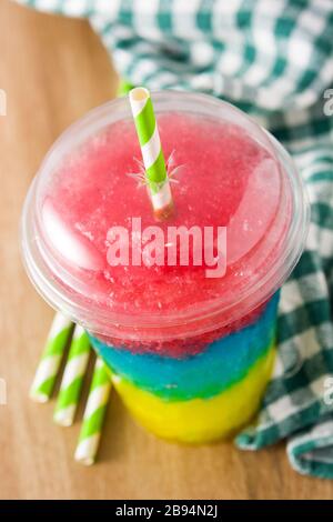 Slushie colorée de différentes saveurs avec paille dans une tasse en plastique Banque D'Images