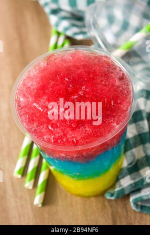 Slushie colorée de différentes saveurs avec paille dans une tasse en plastique Banque D'Images