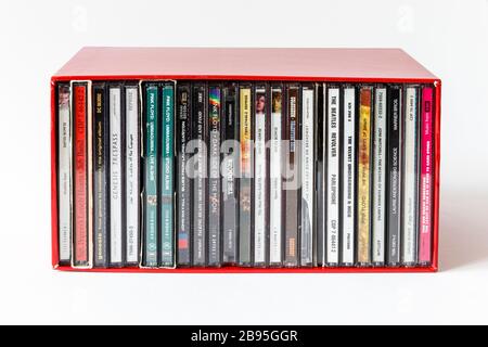 Une boîte rouge contenant des CD empilés verticalement d'artistes des années 60 et 70, des titres visibles sur les épines Banque D'Images