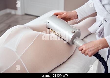 Le masseur fait un massage anti-cellulite dans la clinique de cosmologie Banque D'Images
