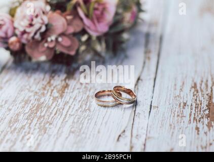 Ensemble de mariage romantique avec anneaux. Composition rustique de mariage de couple avec anneaux, couronne de fleur et boutonnière. Accessoires de mariage assortis. Banque D'Images