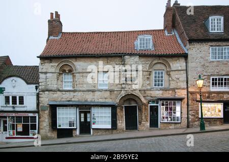 La maison de Jew est l'une des plus anciennes maisons de ville existantes en Angleterre. Il est situé sur la colline escarpée de Lincoln, juste en dessous du tribunal de Jew. La maison a traditionnellement été associée à la communauté juive prospère de Lincoln médiéval. L'hystérie antisémite a été attisée par un célèbre libelle de sang 1255, prétendant faussement le meurtre qu'un enfant, appelé petit Saint Hugh de Lincoln, a été rituellement tué par les juifs. En 1290, toute la communauté juive a été expulsée d'Angleterre, et la Maison du Juif aurait été saisie d'un propriétaire juif. Banque D'Images