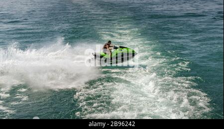 LAC DE GARDE, ITALIE - SEPTEMBRE 2018 : personne qui monte à bord d'un jet rapide de saut à ski à partir du sillage d'un ferry pour passagers sur le lac de Garde. Banque D'Images