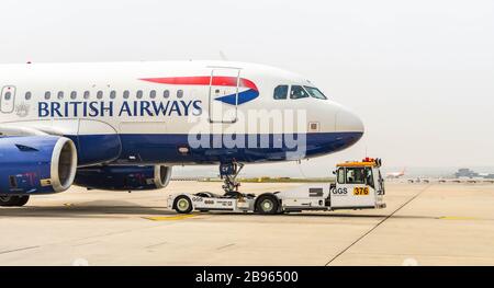 AÉROPORT DE LONDRES GATWICK, ANGLETERRE - AVRIL 2019: British Airways Airbus A 319 repoussée du terminal par un remorqueur à l'aéroport de Londres Gatwick Banque D'Images