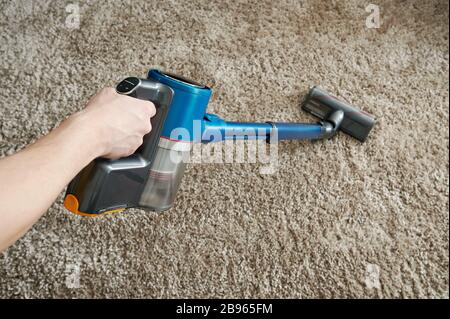 Nettoyer la moquette avec un aspirateur sur fond gris Banque D'Images