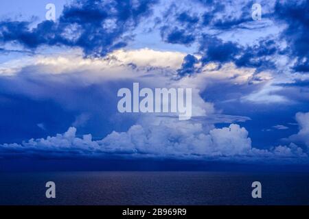 Des corps uniques de cumulus orage nuages au-dessus des eaux de l'océan horizon ligne dans le ciel bleu fond. Environnement climat concept Banque D'Images