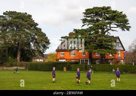 Enfants jouant sur le vert du village à Brockham, Surrey, Angleterre Banque D'Images