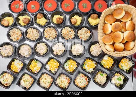 Livraison de nourriture. Différent en plastique jetable boîte à déjeuner avec des aliments naturels sains. Bouillon de poulet, soupe écrasée, purée de pommes de terre avec côtelettes, fruits de mer Banque D'Images