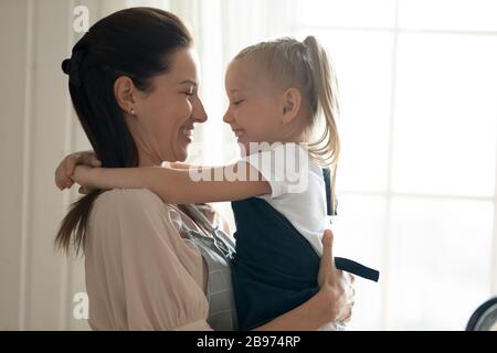 Maman souriante et petite fille douée partager le moment doux Banque D'Images