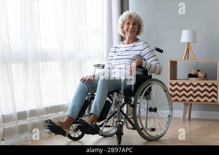 Portrait d'une heureuse femme handicapée en fauteuil roulant Banque D'Images