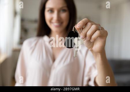 Une femme souriante tient les clés de la maison entre les mains Banque D'Images