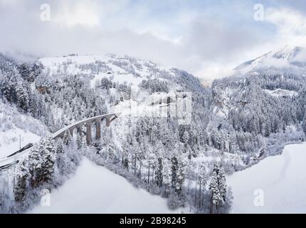 Vue aérienne du Landwasser Viaduc avec chemin de fer sans célèbre train en hiver, site touristique de la Suisse, neige, rivière et montagnes Banque D'Images