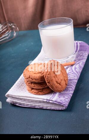 Tasse de lait avec biscuits à la cannelle sur la nappe Banque D'Images