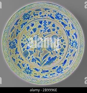 Chargeur avec un plat avec un qilin qilin près d'un rocher parmi les plantes, grand plat en porcelaine, décor peint en bleu. Sur l'étagère dans un médaillon d'un qilin en flammes à proximité d'un rocher, entouré de plantes à fruits (raisin, banane, melon). La paroi interne avec lotus la vigne. Sur le bord intérieur d'une serviette avec bande de travail. Avec une bande morte sur le mur extérieur. Deux fissures dans le bord. Le fond est non. Yuan en porcelaine bleu et blanc, encore d'autres animaux fabuleux qui ne peuvent être classés dans 25 FF 2 25 FF - 7 ornement, dérivés de formes végétales, anonyme, la Chine, l'c. 1350, Yuan-dynastie (1279 Banque D'Images