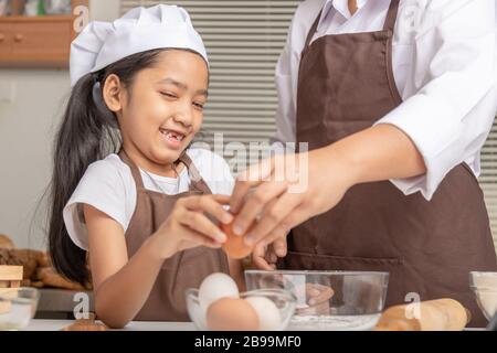 La mère et la fille aident à recueillir des œufs pour cuisiner avec bonheur. Sélectionner la profondeur de champ faible focale de mise au point. Banque D'Images