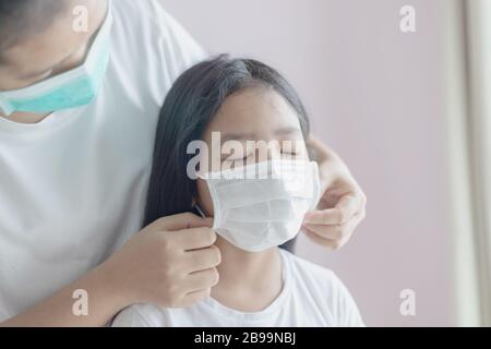 La mère porte un masque pour sa fille. La femme et la fillette portent un masque médical de protection. La protection de l'épidémie de grippe, Coronavirus Banque D'Images