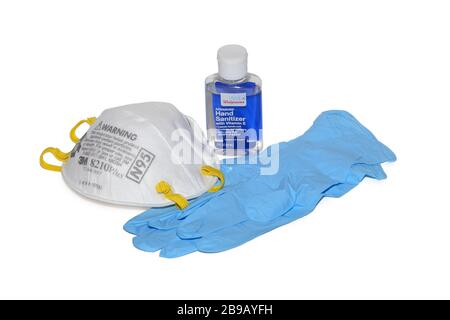 Un flacon de désinfectant pour les mains, un masque facial N95 et des gants jetables en nitrile isolés sur un fond blanc. Image découpée. Banque D'Images