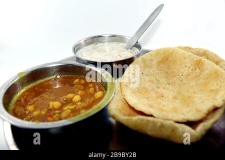 Plat indien poulet épicé au curry de pois, également connu sous le nom de Chola/Chana Masala ou couramment Chole, servi avec du puri frit Banque D'Images